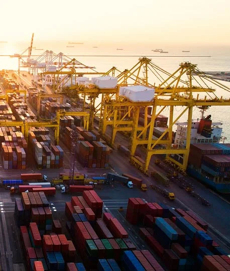 Aerial view of port terminal with container cranes at sunset